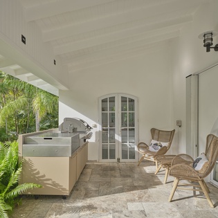 Your private covered terrace features outdoor kitchen and cozy seating overlooking tropical gardens.