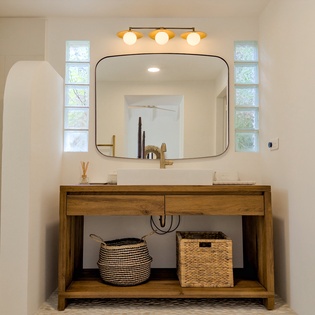 Refresh in your private bathroom with dual vessel sinks, warm wood tones, and soft natural light—a serene start to your day.