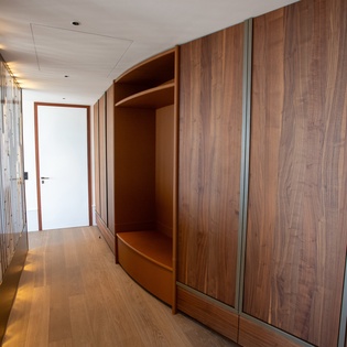 Your sleek entryway features abundant built-in storage with warm wood tones, creating an organized and welcoming arrival experience.