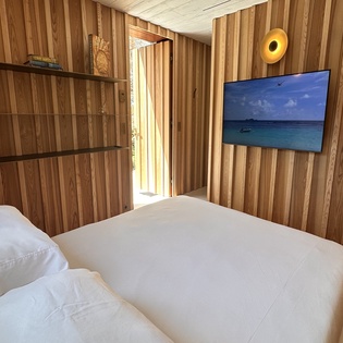 Unwind in your cozy wooden retreat with crisp linens and ocean views on the wall-mounted TV.