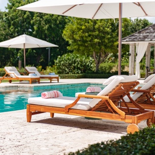 Sink into poolside bliss on cushioned loungers with fresh towels waiting. Your private oasis invites sun-soaked afternoons under shade umbrellas, just steps from crystal-clear water.