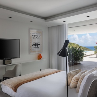Luxurious bedroom with stunning ocean views where you'll wake to tropical paradise through floor-to-ceiling windows.