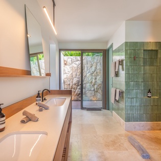Step into your spa-like sanctuary with stunning green tiles and natural stone views through floor-to-ceiling windows.