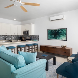 Relax in your stylish open-plan living space with modern kitchen, comfortable seating, and coastal-inspired decor that makes you feel instantly at home.