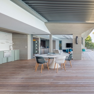 Your stunning outdoor dining flows seamlessly to your stylish kitchen, where warm wood decking meets tropical breezes and panoramic views.