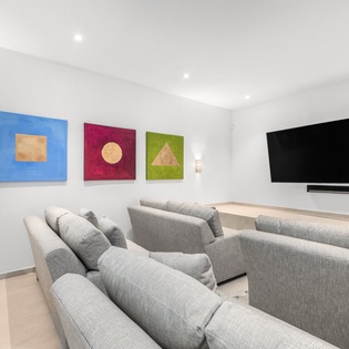 Sink into plush gray sectionals in your private theater room, where colorful artwork and surround sound create the perfect movie night experience.