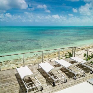 Stunning beachfront deck with crystal-clear turquoise waters and pristine white sand stretching endlessly before your eyes.