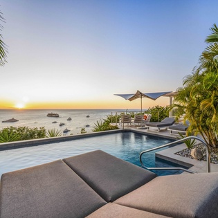 Watch golden sunsets from your private infinity pool, surrounded by swaying palms with breathtaking ocean views stretching to the horizon.