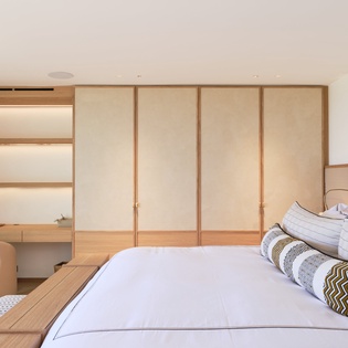 Your serene bedroom features warm wood tones, crisp linens, and thoughtful built-in storage for ultimate comfort and organization.