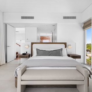 Wake up in this serene master suite with luxurious linens and stunning views through floor-to-ceiling windows.