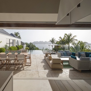 Step onto your private terrace where ocean breezes meet stylish outdoor living, complete with dining and lounge areas overlooking tropical paradise.