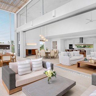 Unwind in this stunning open-plan living space where modern luxury meets tropical elegance, with soaring ceilings and seamless indoor-outdoor flow.