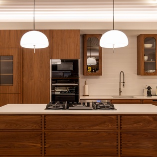 Your gourmet kitchen features rich walnut cabinetry, premium appliances, and elegant pendant lighting - perfect for cooking memorable meals during your stay.