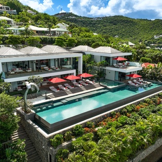 Stunning modern villa nestled in lush tropical mountains, featuring expansive pool and contemporary architecture.
