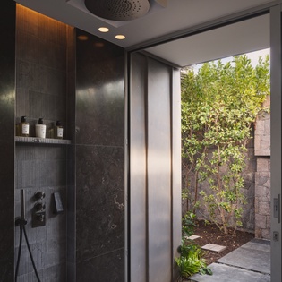 Step into your private spa-like shower with luxurious rainfall head and seamless garden views through floor-to-ceiling glass.