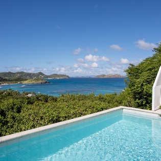 Stunning infinity pool overlooking turquoise Caribbean waters and tropical islands creates the perfect backdrop for your island getaway.