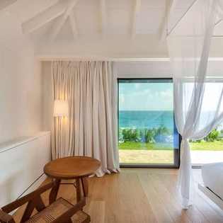 Wake up to endless ocean views framed by billowing white curtains and vaulted ceilings. Your private sanctuary blends coastal elegance with soothing natural light and serene sea vistas.