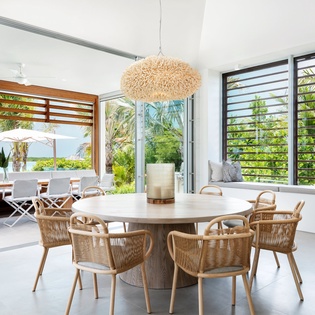 Gather around this stunning dining table where tropical breezes flow through and lush garden views create the perfect backdrop for your meals.