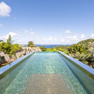 Dive into your private infinity pool as tropical breezes carry ocean scents and panoramic views stretch endlessly before you.