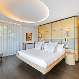 Drift into luxury in your sophisticated suite, where warm woods meet modern design beneath a stunning illuminated ceiling.