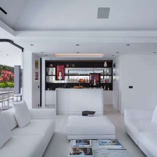 Sink into plush white sofas while gazing at tropical gardens. Your private bar awaits with chilled drinks for poolside entertaining.