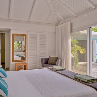 Wake up in your serene bedroom sanctuary where tropical views and soft ocean breezes flow through glass doors onto your private terrace.