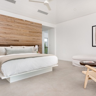 Unwind in your serene bedroom featuring a plush bed, cozy seating area, and warm wood accents creating the perfect peaceful retreat.