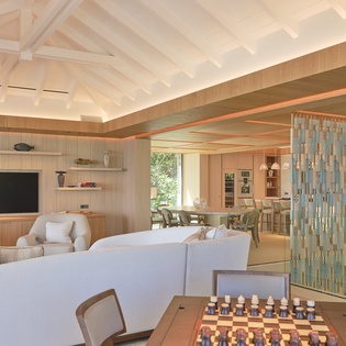 Unwind in your spacious living room with soaring vaulted ceilings and warm wood accents creating a serene modern retreat.