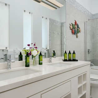 Step into a beautifully appointed spa-inspired bathroom with dual vanities, a spacious walk-in shower, and thoughtfully curated amenities for your comfort and relaxation.