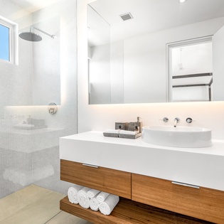 Your sleek bathroom features a rainfall shower and modern vanity, creating a spa-like retreat for refreshing mornings.