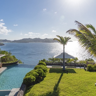 Stunning oceanfront property with infinity pool overlooking pristine waters and tropical islands beyond.