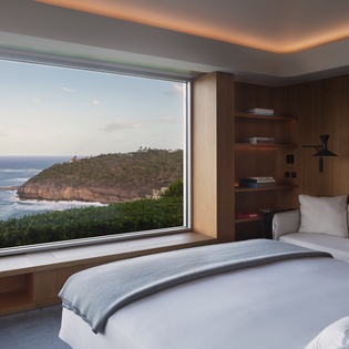 Wake up to breathtaking ocean views from your plush bed, where warm wood tones and modern comfort create your perfect coastal retreat.