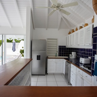 Your fully equipped kitchen opens to stunning pool and ocean views, where cooking becomes a joy with tropical breezes and azure waters as your backdrop.