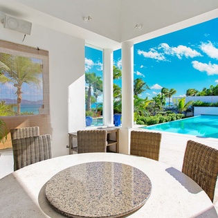 Picture yourself dining here, cooled by gentle breezes, with lush palms swaying and your private pool sparkling just beyond. Every meal feels like a tropical escape in this light-filled, elegant space.