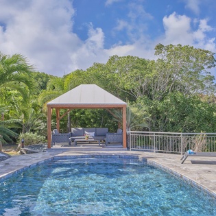 Your private pool paradise awaits with tropical palms and a shaded cabana where you can unwind in pure bliss.