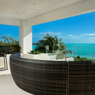 Unwind in your private terrace seating with breathtaking turquoise ocean views stretching to the horizon.
