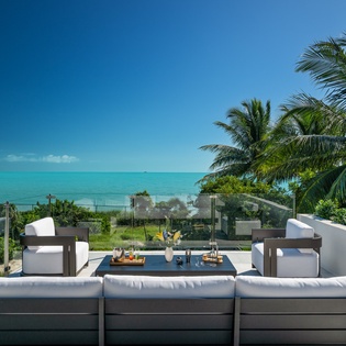 Modern rooftop terrace with ocean views and tropical palms creates the perfect setting for memorable moments.
