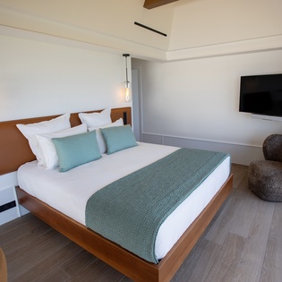 Sink into comfort on crisp white linens with aqua accents. Your modern retreat features stylish pendant lighting and sleek entertainment.