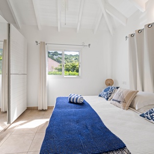 Drift off in your bright, coastal-inspired bedroom where sea breezes flow through garden views and crisp linens await your arrival.