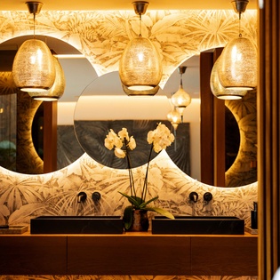 Sink into luxury with stunning dual vanities, golden pendant lights, and tropical-inspired design that make your daily routine feel like a spa retreat.
