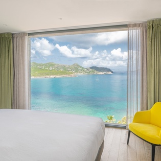 Wake up to breathtaking turquoise waters and rolling coastline from your bright, modern bedroom with premium amenities and stunning sea views.