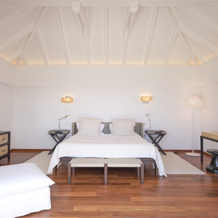 Unwind in your spacious bedroom with soaring ceilings, warm wood floors, and crisp linens awaiting your arrival.