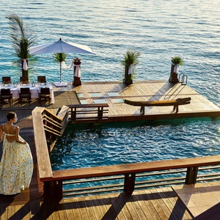 Waterfront dining deck with crystal-clear ocean views, perfect for sunset dinners and intimate waterside moments.