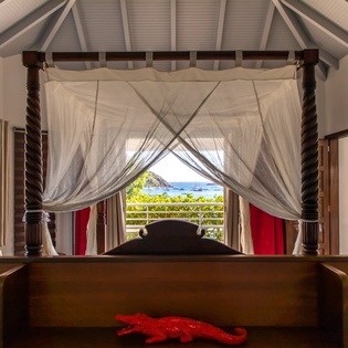 Wake up to stunning ocean views through your canopy bed's flowing curtains, where Caribbean breezes meet luxurious comfort.
