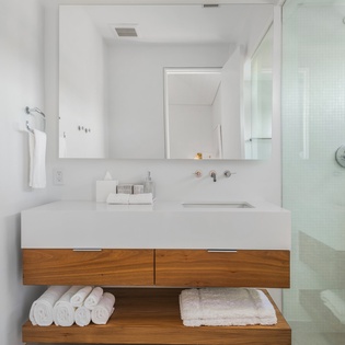 Your modern bathroom features a sleek floating vanity with spa-quality towels and a glass-enclosed shower for your daily refresh.