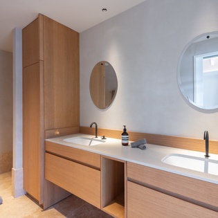 Refresh in your beautifully designed bathroom featuring warm wood vanity, dual sinks, and modern fixtures for ultimate comfort.
