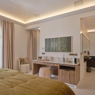 Your elegant bedroom features a stylish TV console and cozy seating area where you can unwind after exploring.