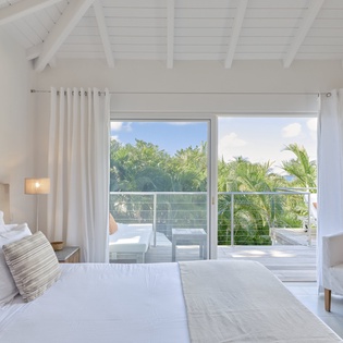 Wake up in your serene bedroom sanctuary with tropical views and private balcony access. Crisp linens and natural light create the perfect retreat.