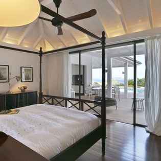 Sink into your elegant four-poster bed while ocean breezes flow through flowing curtains onto your private terrace.