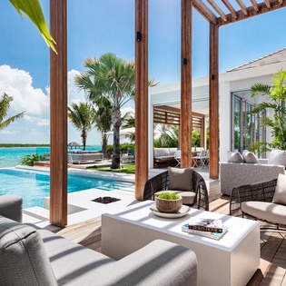 Sink into plush outdoor seating overlooking your private pool and turquoise waters, where tropical palms frame endless ocean views.
